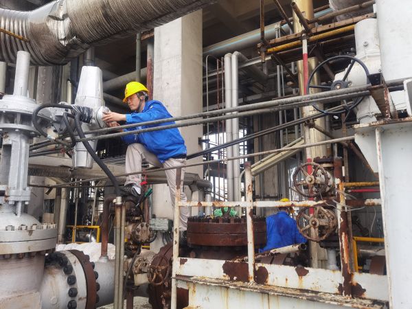 氣化爐上，柳曦、徐騰飛冒雨調(diào)試氣化爐電動(dòng)閥.jpg