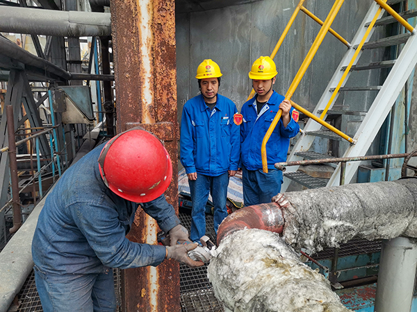 10月17日下午，在1號鍋爐暖風器S2管道檢測處，安朝陽和張跟潮在監(jiān)護外協(xié)人員工作.jpg