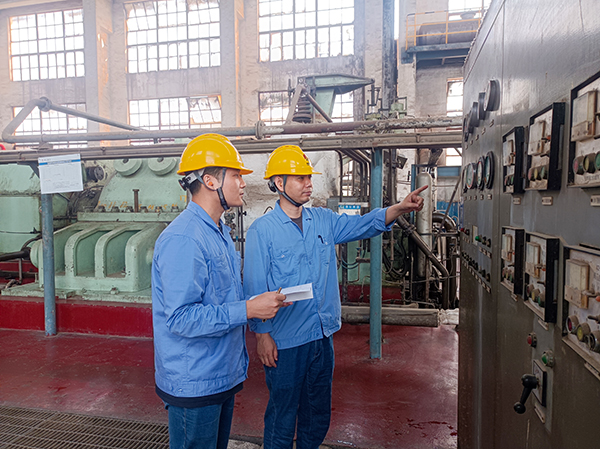 機組現(xiàn)場，老師傅正在向年輕員工傳授操作技藝.jpg
