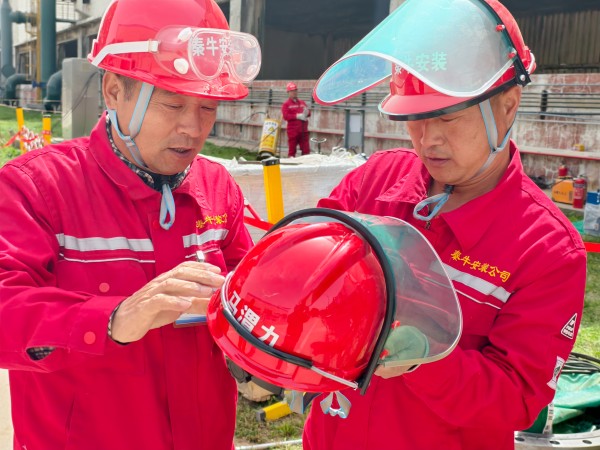 團結(jié)協(xié)作 施工人員正在為其工友安裝安全面罩.jpg